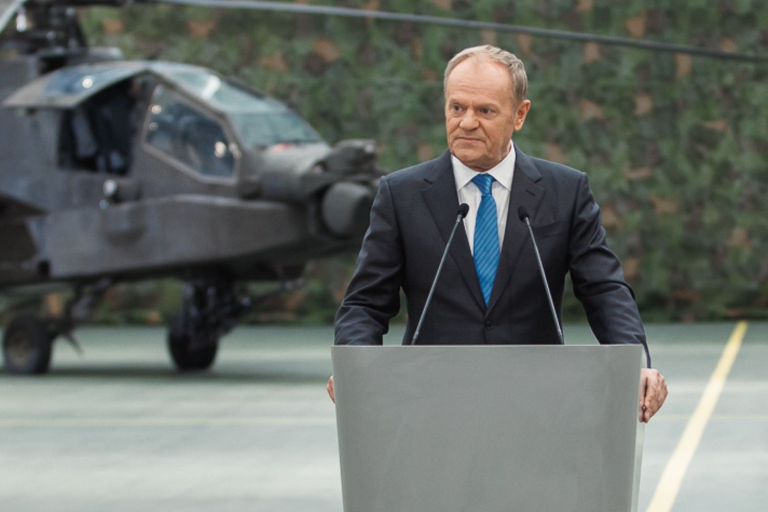 Donald Tusk na tle wojskowego helikoptera