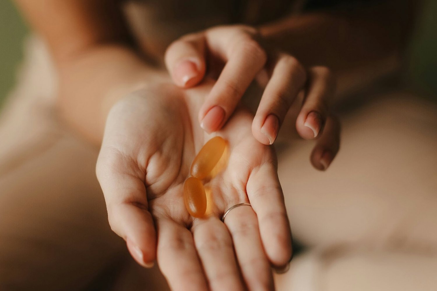 Kwasy omega-3 pod lupą kobieta z tabletkami