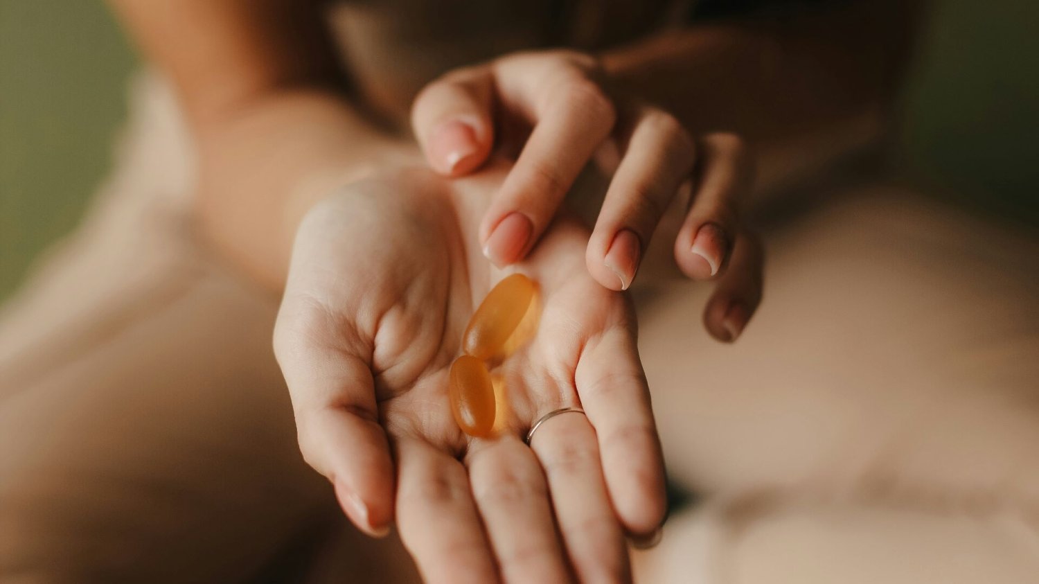 Kwasy omega-3 pod lupą kobieta z tabletkami