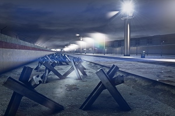 302 wieże strażnicze z zachodzącymi na siebie strefami obserwacji. Na wieżach ruchome reflektory, całość przedpola muru oświetlona regularnie rozmieszczonymi latarniami, psy patrolujące, których smycze zamocowano do biegnących nad ziemią drutów. Tak wyglą