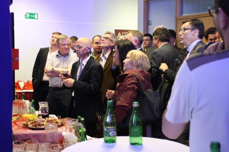 Działacze PiS wpatrzeni w planszę z sondażowymi wynikami wyborów