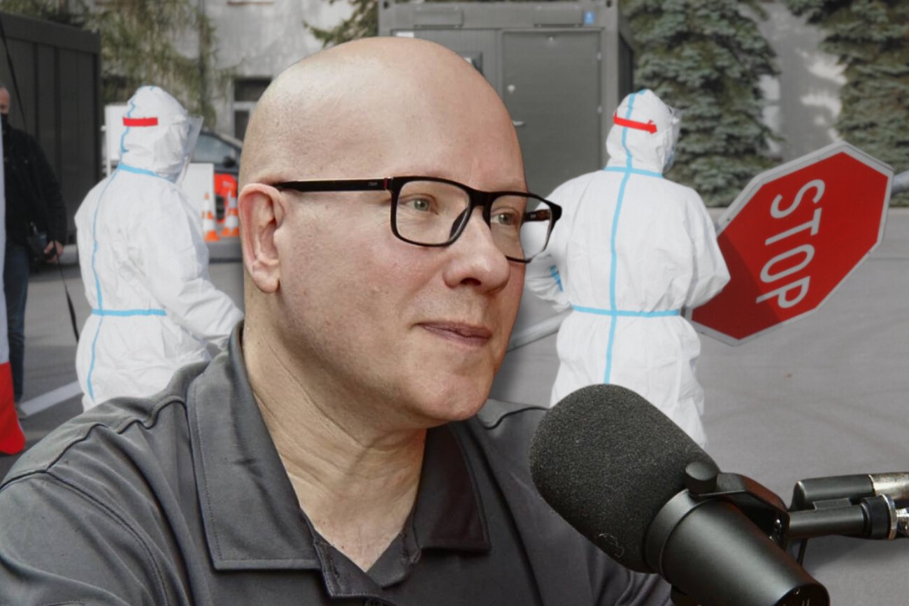 Dr hab. Tomasz Dzieciątkowski. W tle zaś ratownicy w strojach przeciw COVID-19.