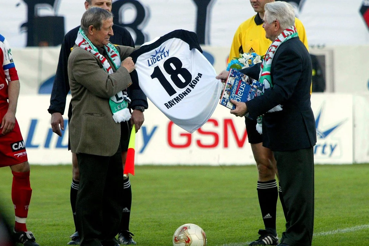 Raymond Kopa odbiera pamiątkową koszulkę od Łucjana Brychczego, legendy Legii Warszawa podczas swojej wizyty w Polsce.