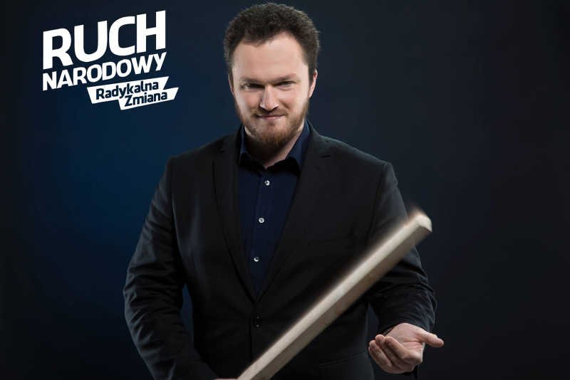 Witold Tumanowicz pozuje na plakacie wyborczym ze sztachetą.