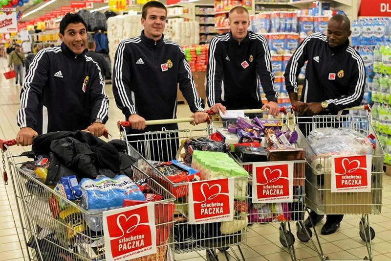 Trudno oprzeć się pokusie ofiarowania datku, gdy zachęcają do tego piłkarze Wisły Kraków. Na zdjęciu w supermarkecie podczas zakupów w ramach akcji "Szlachetna Paczka".