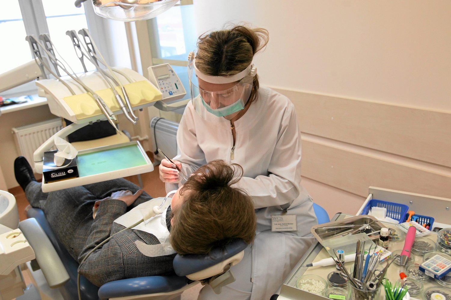 Dentysta leczący zęby pacjenta w stanie pandemii koronawirusa (covid-19).