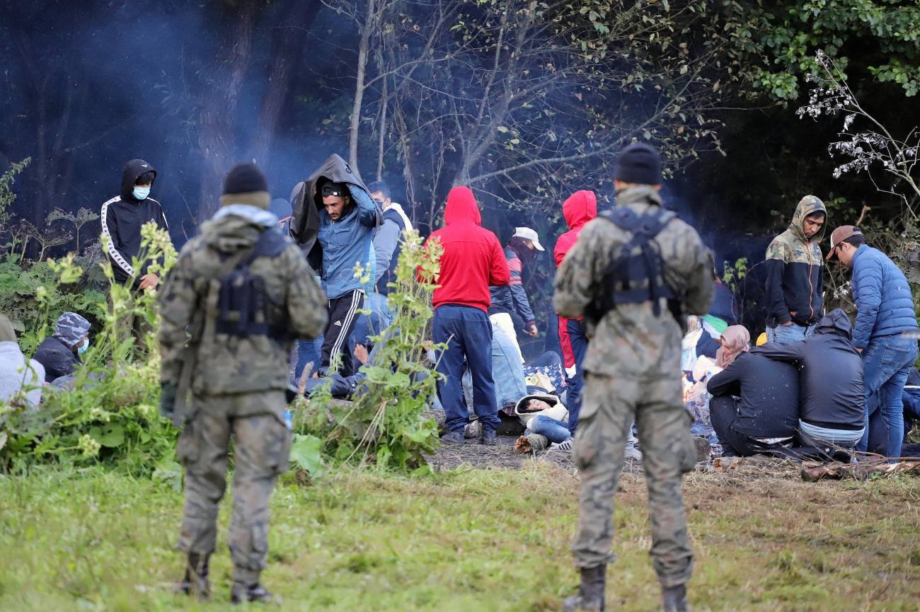 Grupa ok. 50 osób z Iraku i Afganistanu (w tym kobiety i dzieci) od kilku dni koczuje na pasie granicznym. Pilnują ich z obu stron uzbrojeni strażnicy.