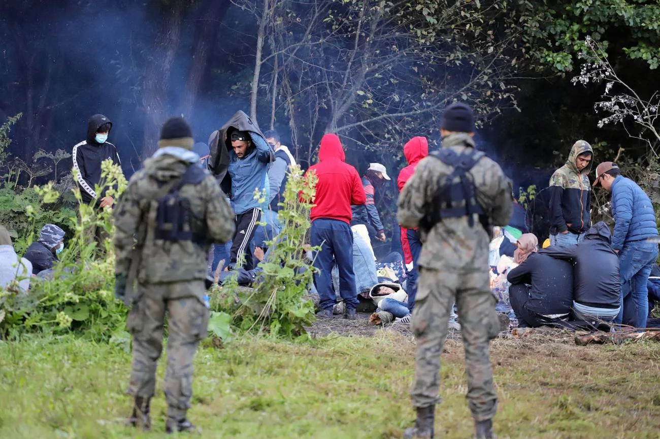Grupa ok. 50 osób z Iraku i Afganistanu (w tym kobiety i dzieci) od kilku dni koczuje na pasie granicznym. Pilnują ich z obu stron uzbrojeni strażnicy.