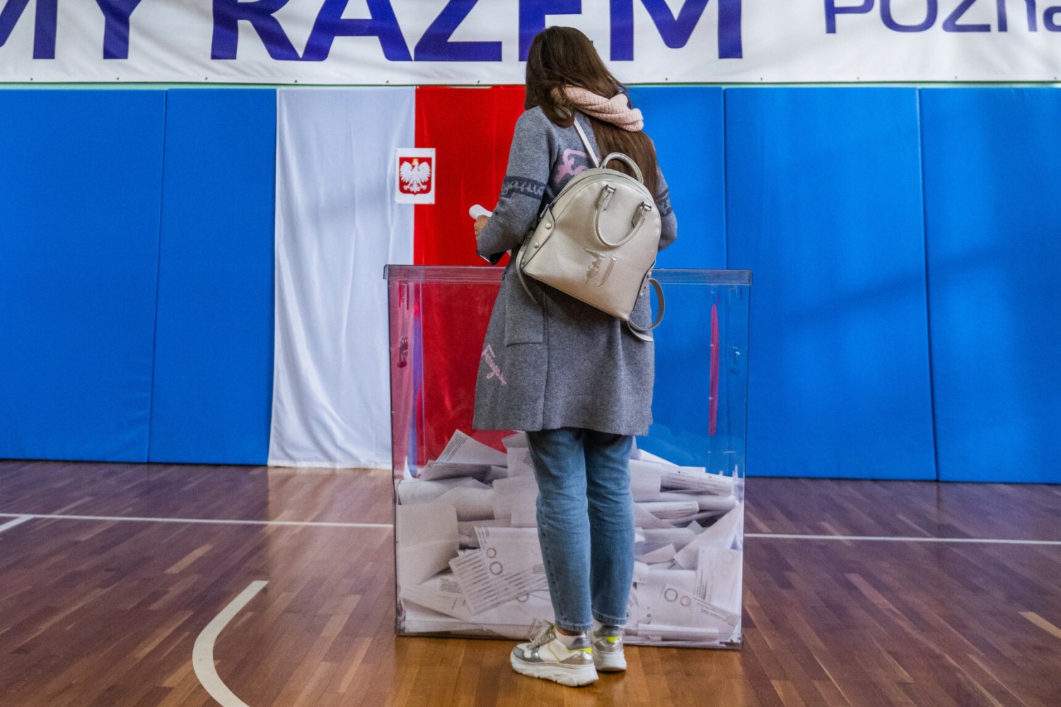 Kobieta głosująca w wyborach przy urnie wyborczej