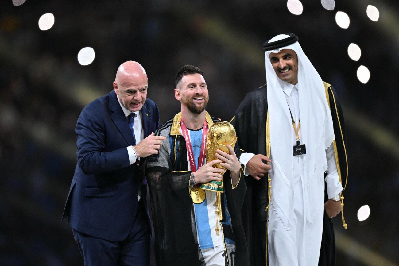 Gianni Infantino, Lionel Messi i Tamim bin Hamad Al Thani na podium po finale MŚ 2022. Argentyńczyk przywdział biszt.