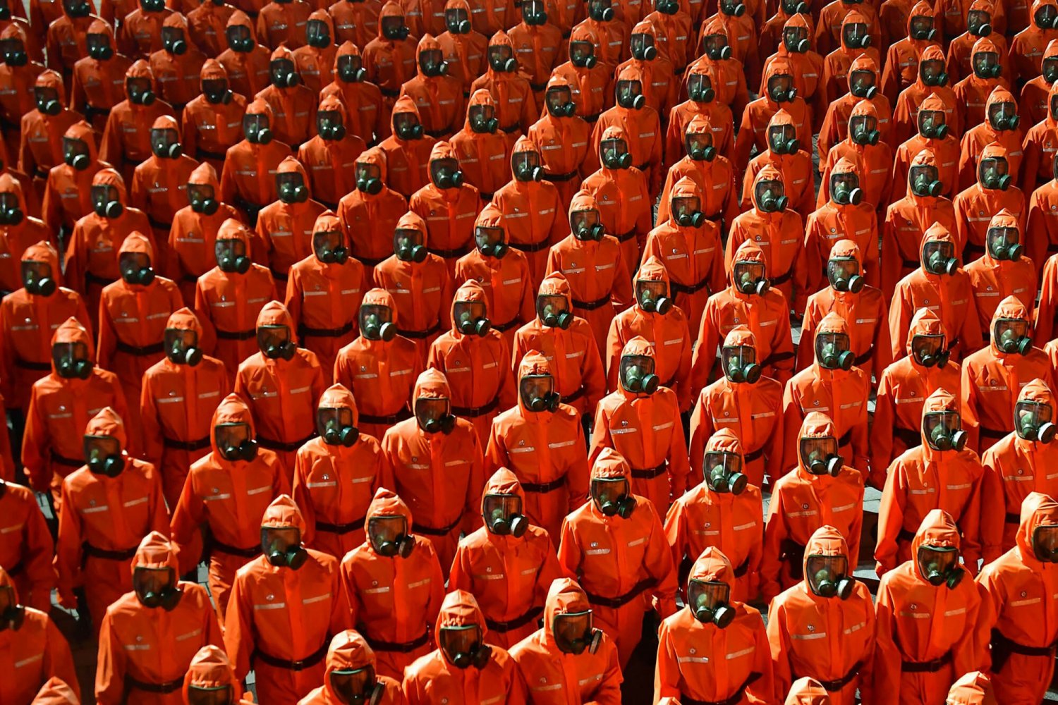 Przez plac Kim Ir Sena przemaszerowali m.in. żołnierze piechoty ubrani w pomarańczowe kombinezony ochronne i noszących maski filtrujące na twarzach.