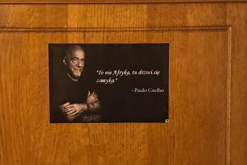 Na plakacie, który zawisł na drzwiach w budynku Rady ds. Uchodźców, widnieją słowa Paulo Coelho: "To nie Afryka, tu drzwi się zamyka".