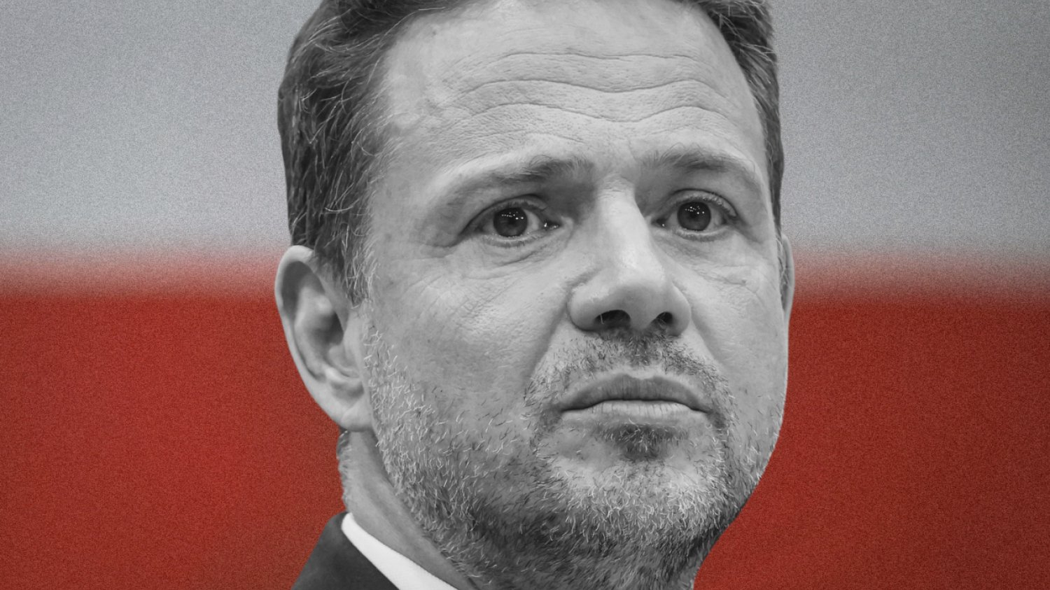Rafał Trzaskowski z poważną miną na tle flagi Polski.