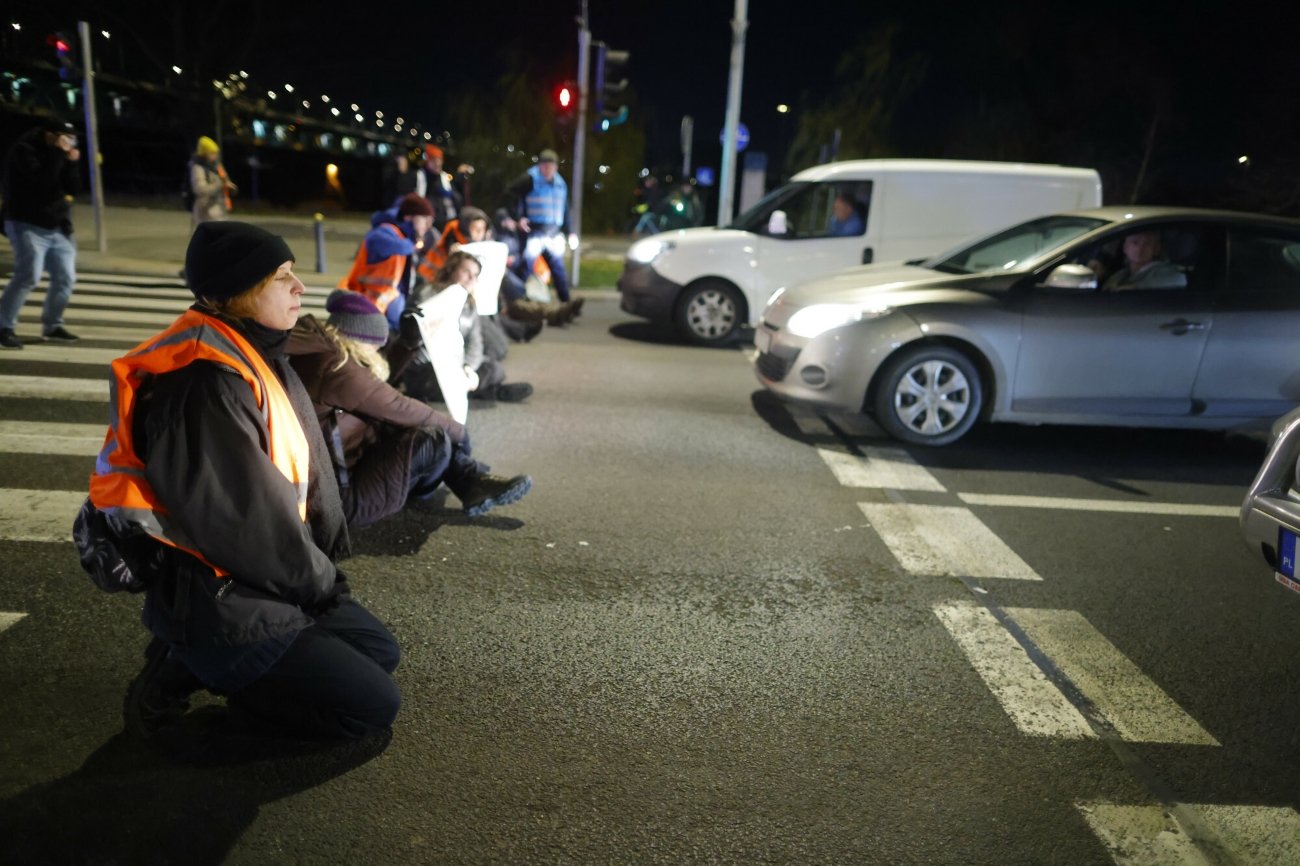 Aktywistki i aktywiści Ostatniego Pokolenia podczas blokady drogi.