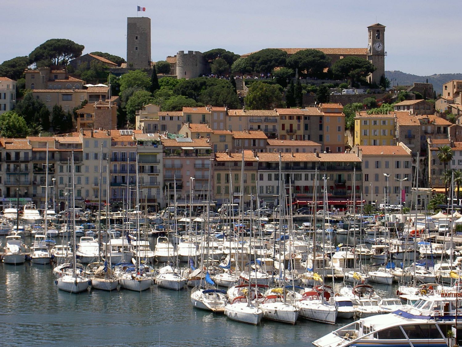 Widok z tarasu Pałacu Festiwalowego na port jachtowy i cytadelę nad Cannes.