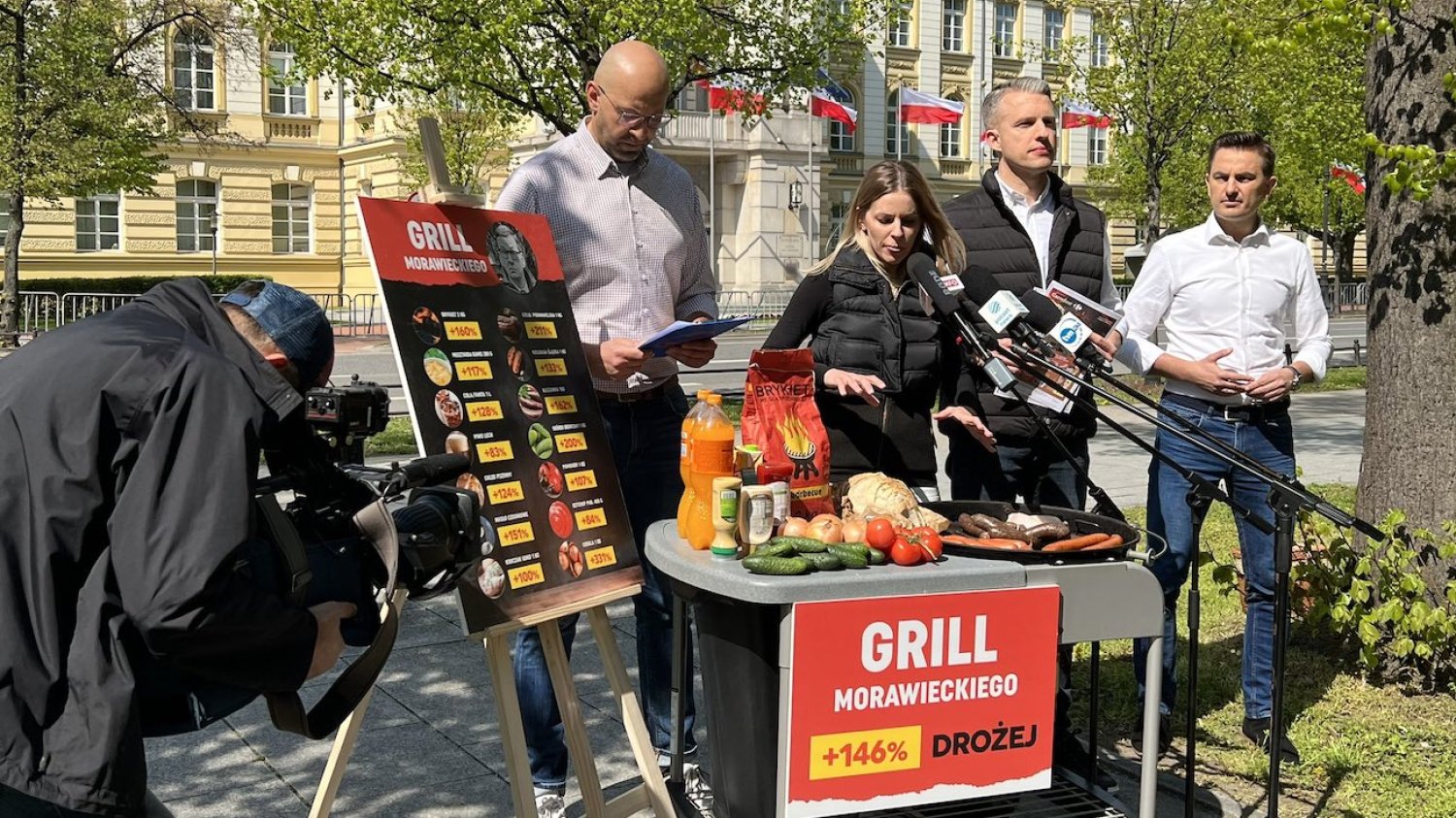 Posłanka i posłowie opozycji podczas akcji "Grill Morawieckiego" przed KPRM w Warszawie. Politycy mówią, że majówka będzie droższa o 146 proc.