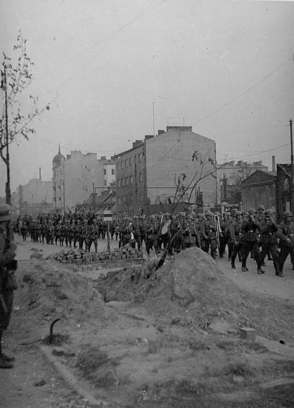 1939 rok, niemieckie oddziały maszerują ulicą Wolską, w tle kamienica pod numerem 67.