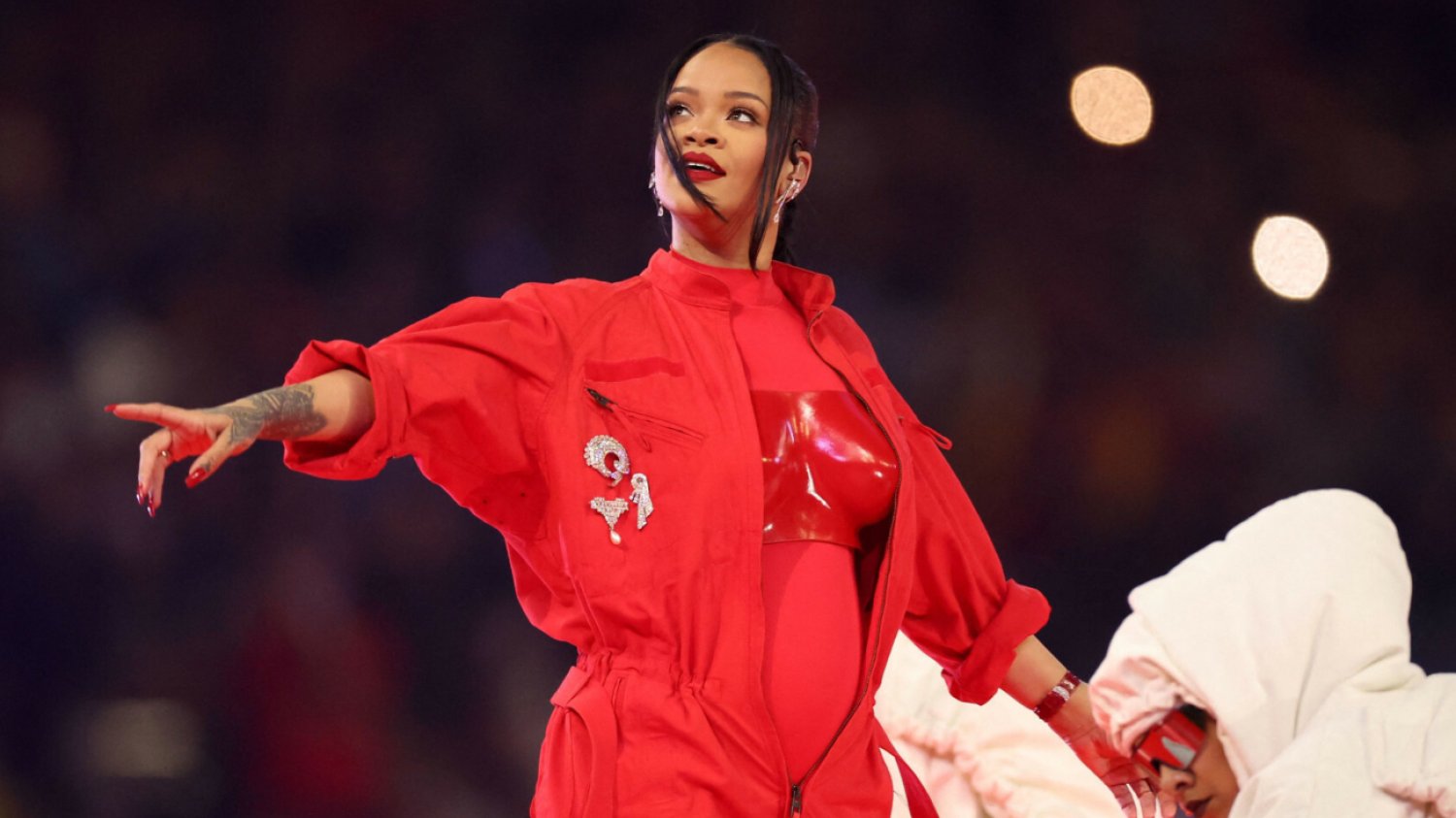 Rihanna ułożyła dłonie w znak trójkąta na scenie Super Bowl 2023. Rihanna ułożyła dłonie w znak trójkąta na scenie Super Bowl 2023.