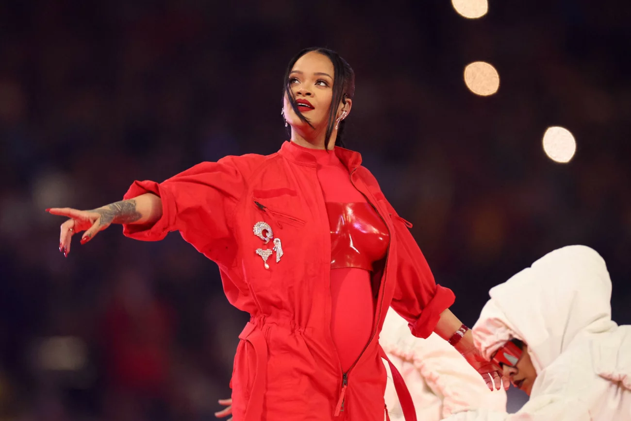 Rihanna ułożyła dłonie w znak trójkąta na scenie Super Bowl 2023. Rihanna ułożyła dłonie w znak trójkąta na scenie Super Bowl 2023.