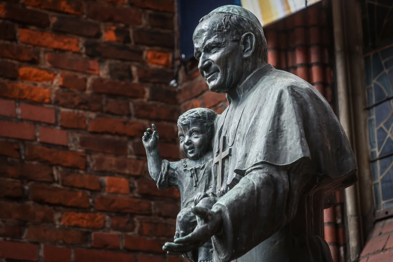 08.04.2023 Gdansk. Pomnik Jana Pawla II stojacy przy kosciele Sw. Brygidy. Pomnik z 1984 roku przedstawia postac papieza trzymajacego w prawej rece dziecko.