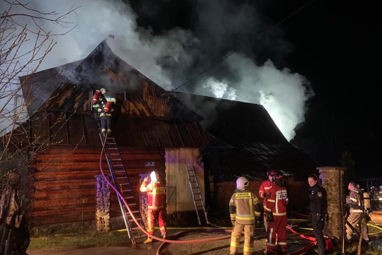strażacy gaszący pożar domu