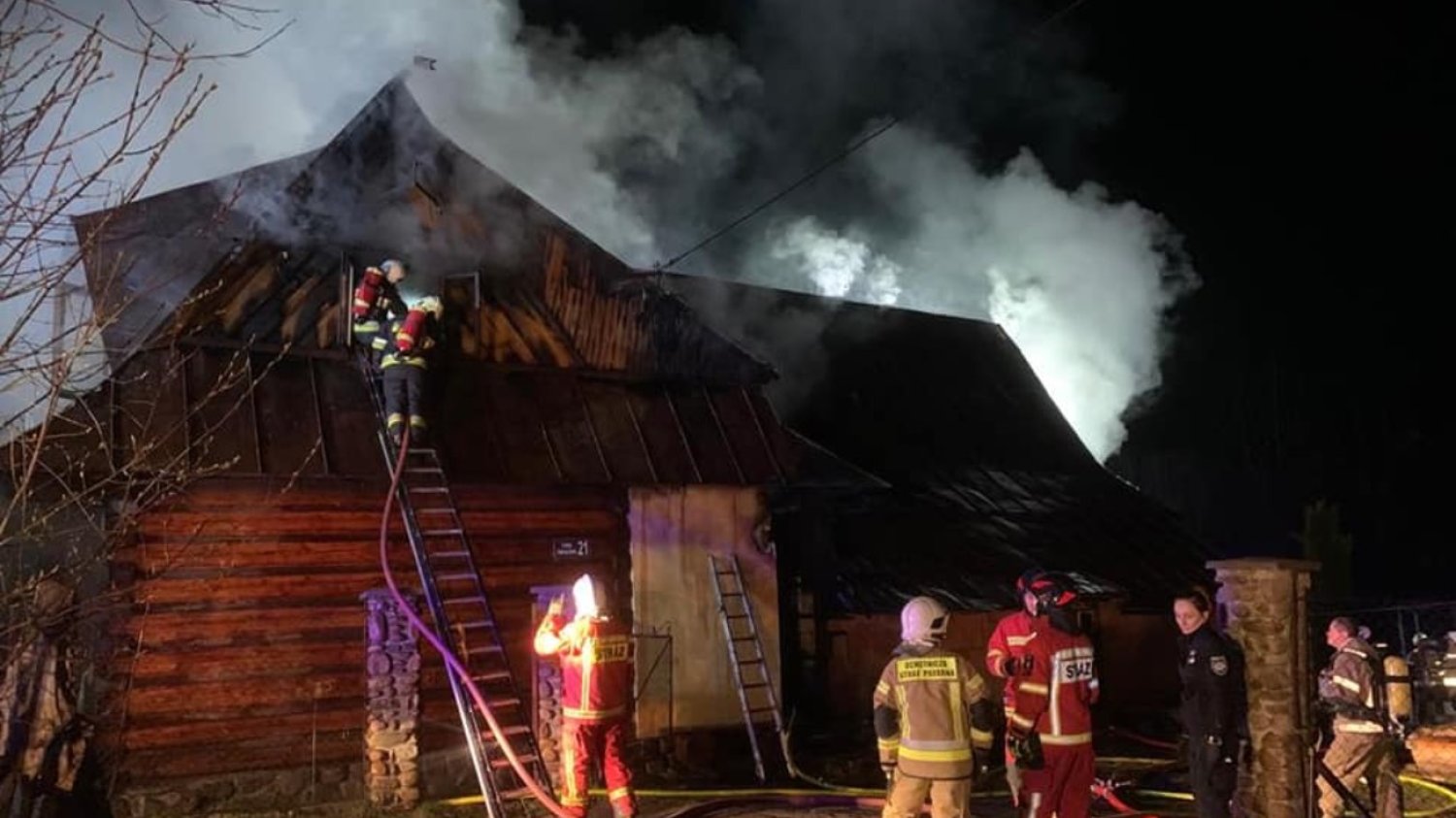 strażacy gaszący pożar domu