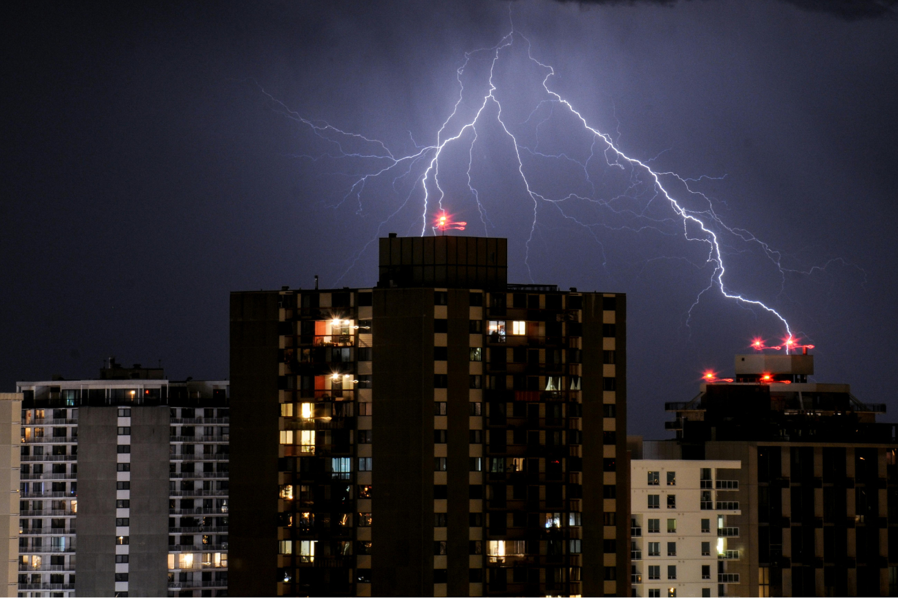 błyskawica nad blokowiskiem panorama blokowiska nocą z ogromną błyskawicą na niebie