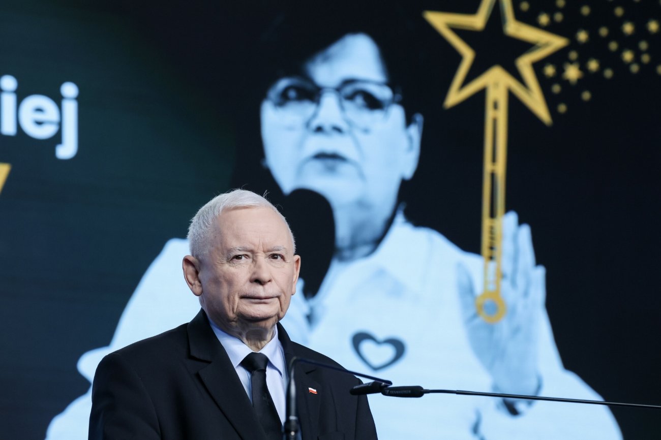 Jarosław Kaczyński przy mikrofonie na konferencji prasowej. W tle zdjęcie ministry zdrowia Izabeli Leszczyny i grafika przedstawiająca czarodziejską różdżkę (2024.10.31).