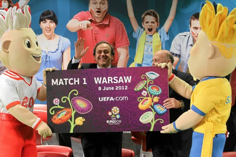 Uśmiechnięty Michel Platini, prezydent UEFA. Tym, których jego organizacja oszukuje, nie jest do śmiechu.