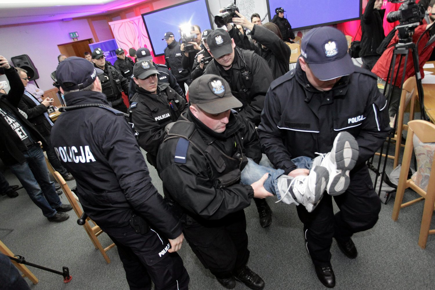 Policjanci "wyprowadzają" z gmachu okopujących.