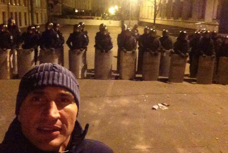 Kliczko pozuje na tle kordonu policji.