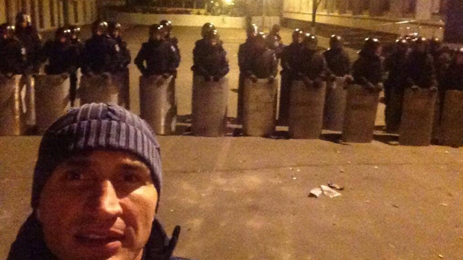 Kliczko pozuje na tle kordonu policji.