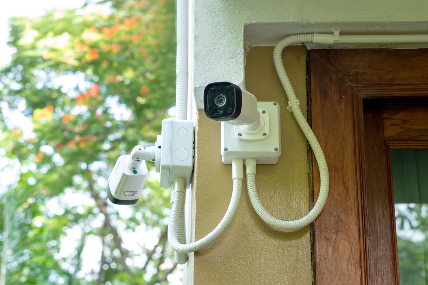 Kamery monitoringu zainstalowana na elewacji domu jednorodzinnego.