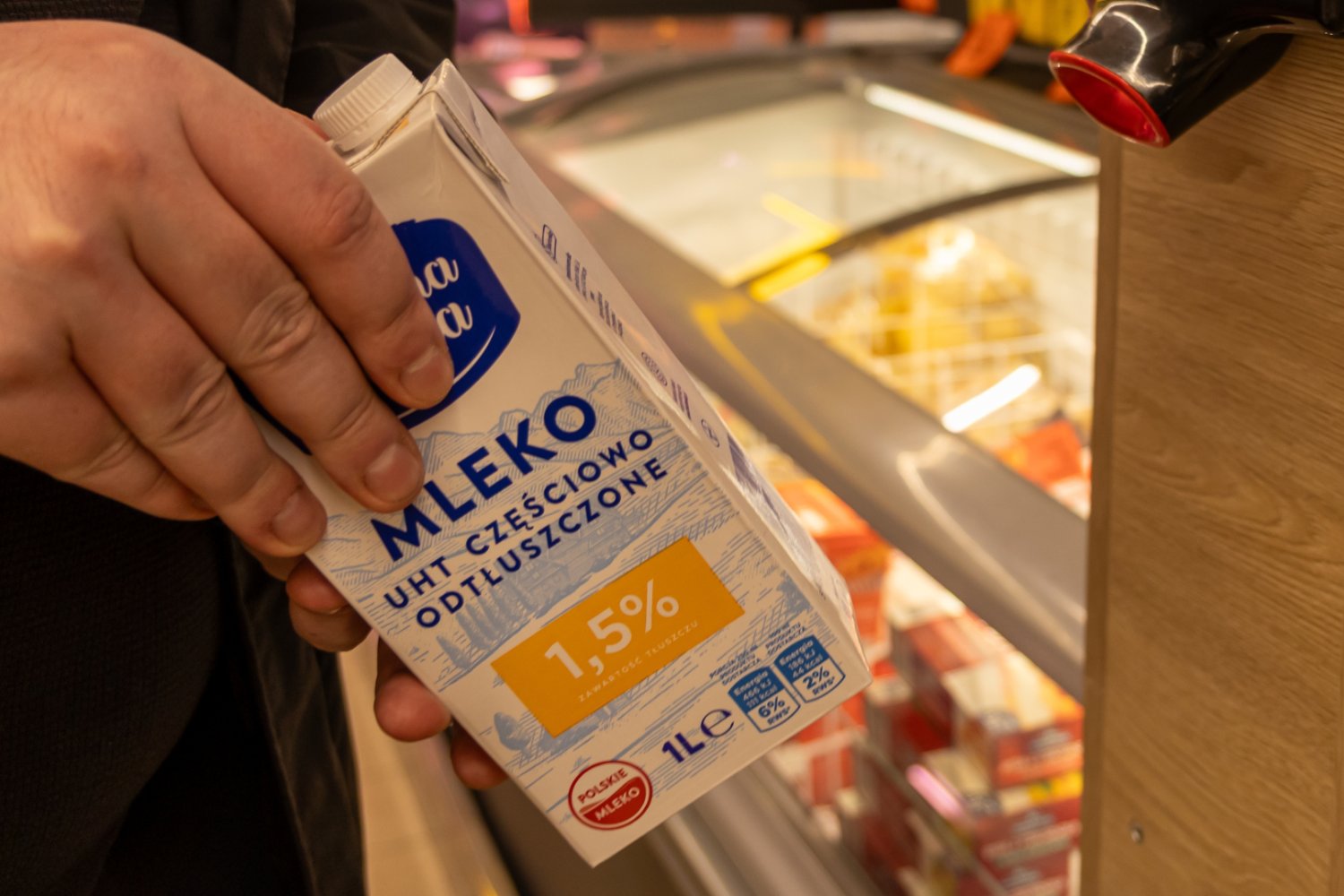 Karton mleka z Biedronki w ręce klienta