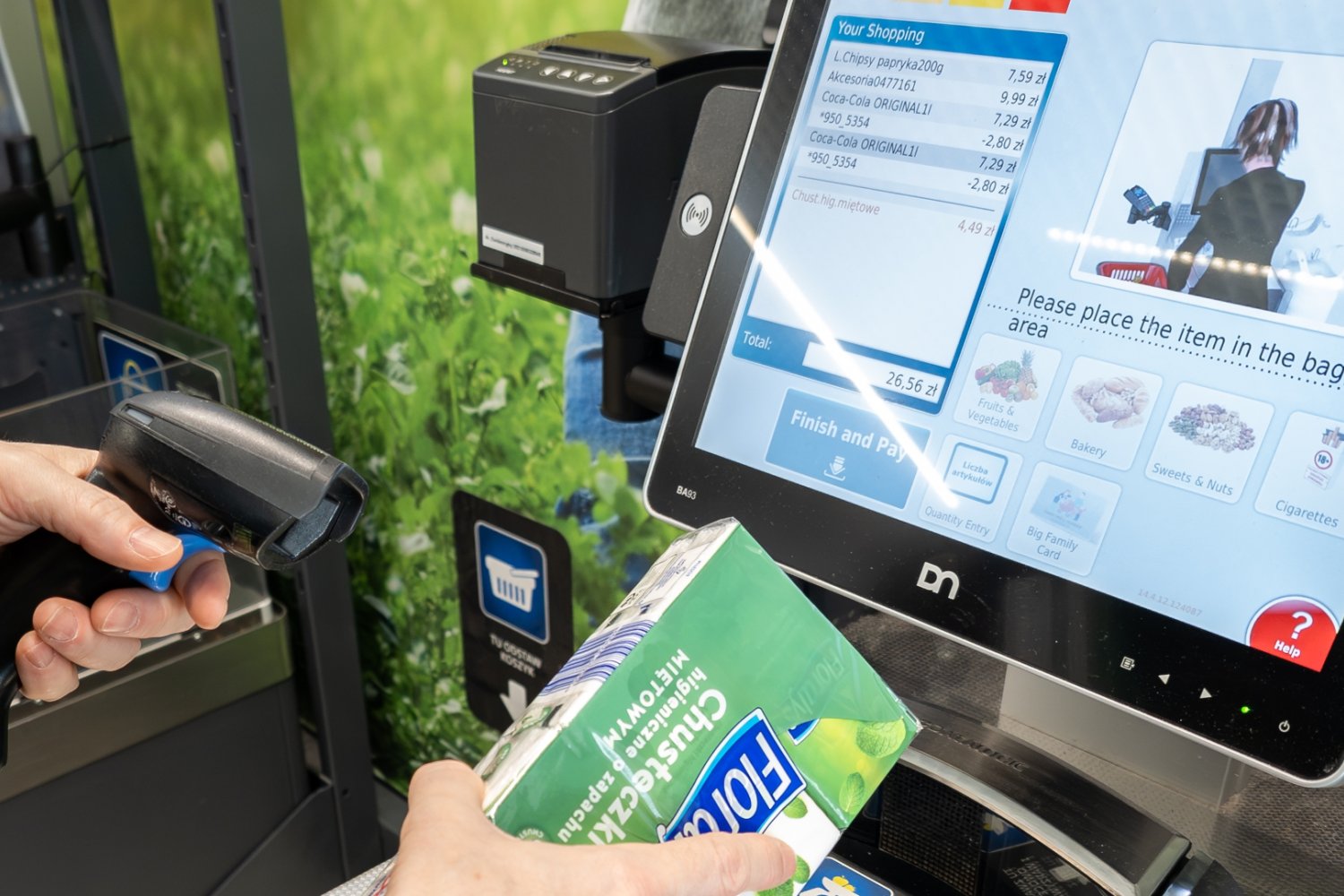 Klient przy kasie samoobsługowej w dyskoncie skanuje produkt