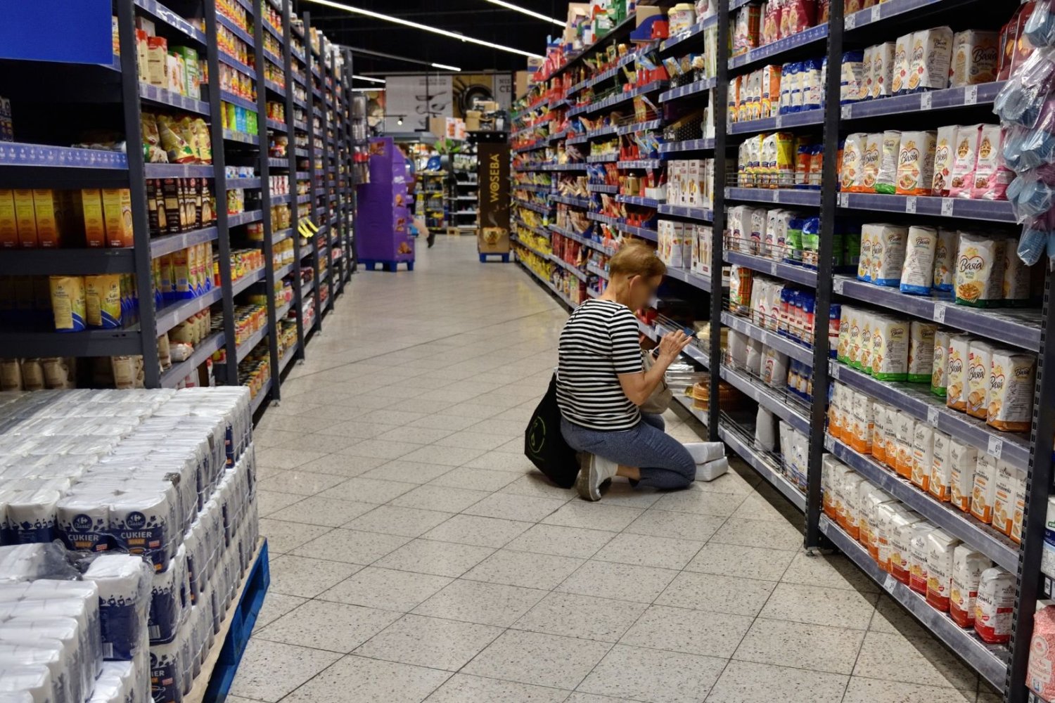 kobieta czytająca etykietę produktu, polski supermarket, półki