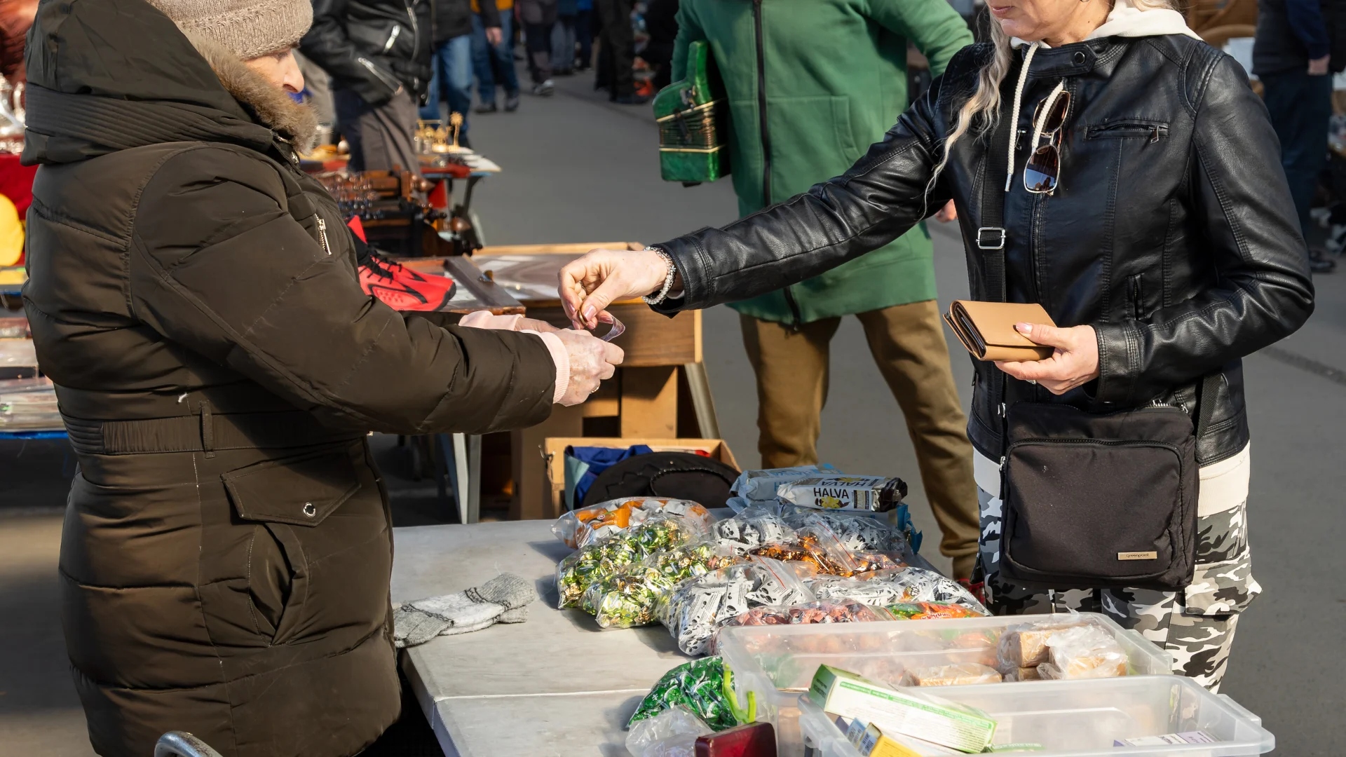 Limit PCC 3000 zł od 3 listopada. Kogo dotyczy zmiana? Kobieta płacąca gotówkę sprzedawcy na pchlim straganie w hali targowej.