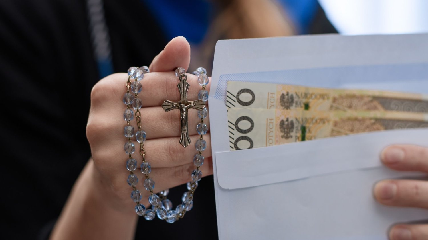 Kobieta z różańcem i kopertą z pieniędzmi
