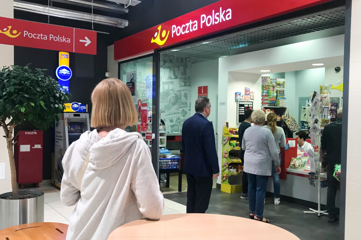 Kolejka osób do okienka w placówce Poczty Polskiej