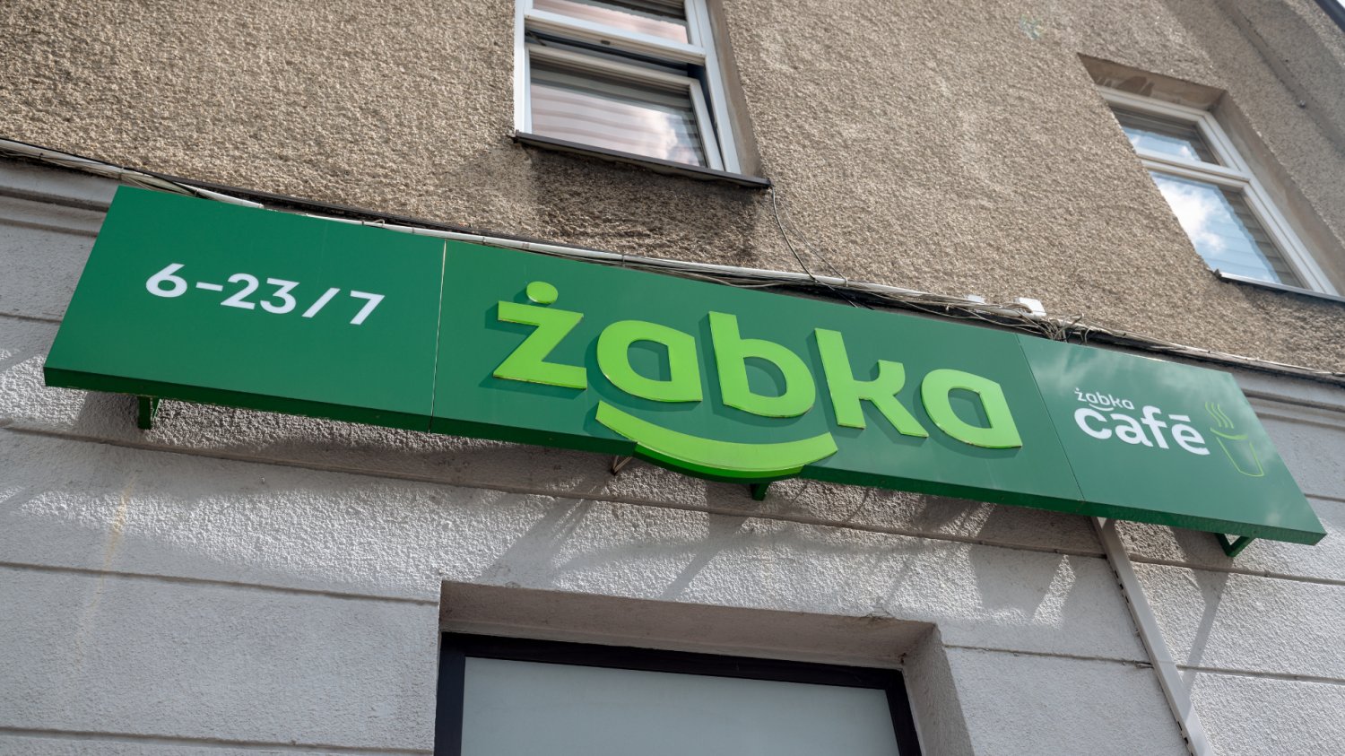 logo sklepu Żabka na tle budynku