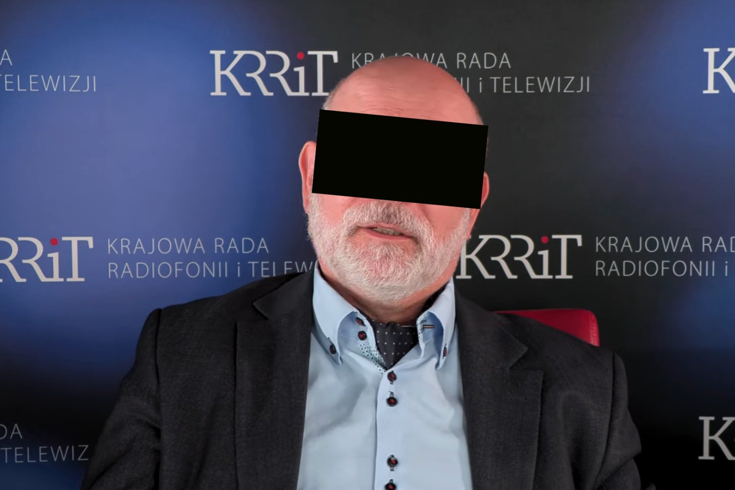 Maciej Ś. na tle bannerów KRRiT