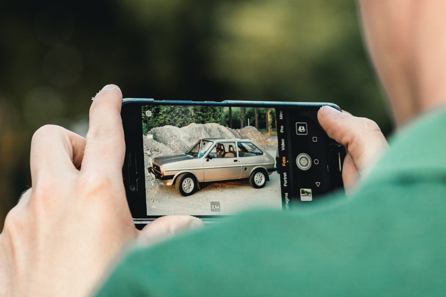 Mężczyzna fotografujący auto.