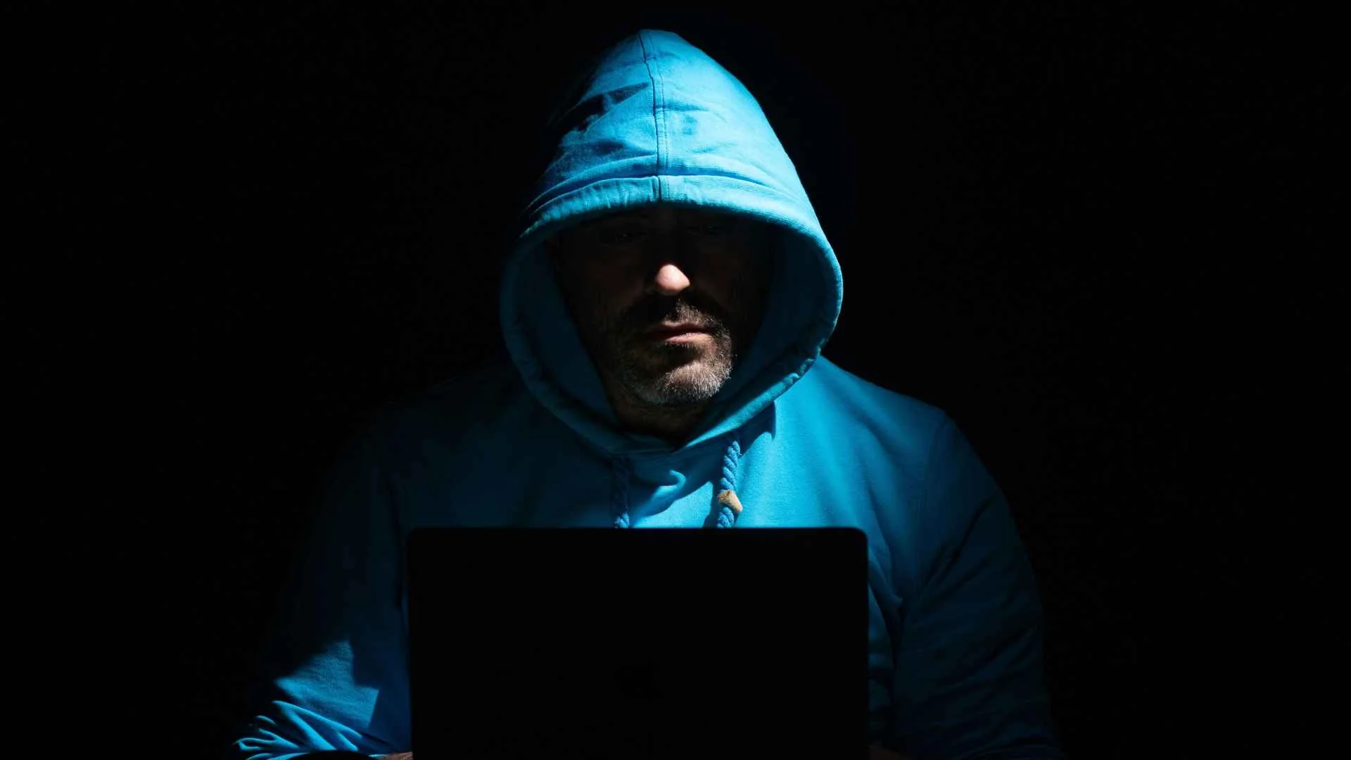 Fakturownia.pl ofiarą ataku. 6 TB dokumentów w rękach jednego cyberprzestępcy mężczyzna-haker w niebieskim kapturze