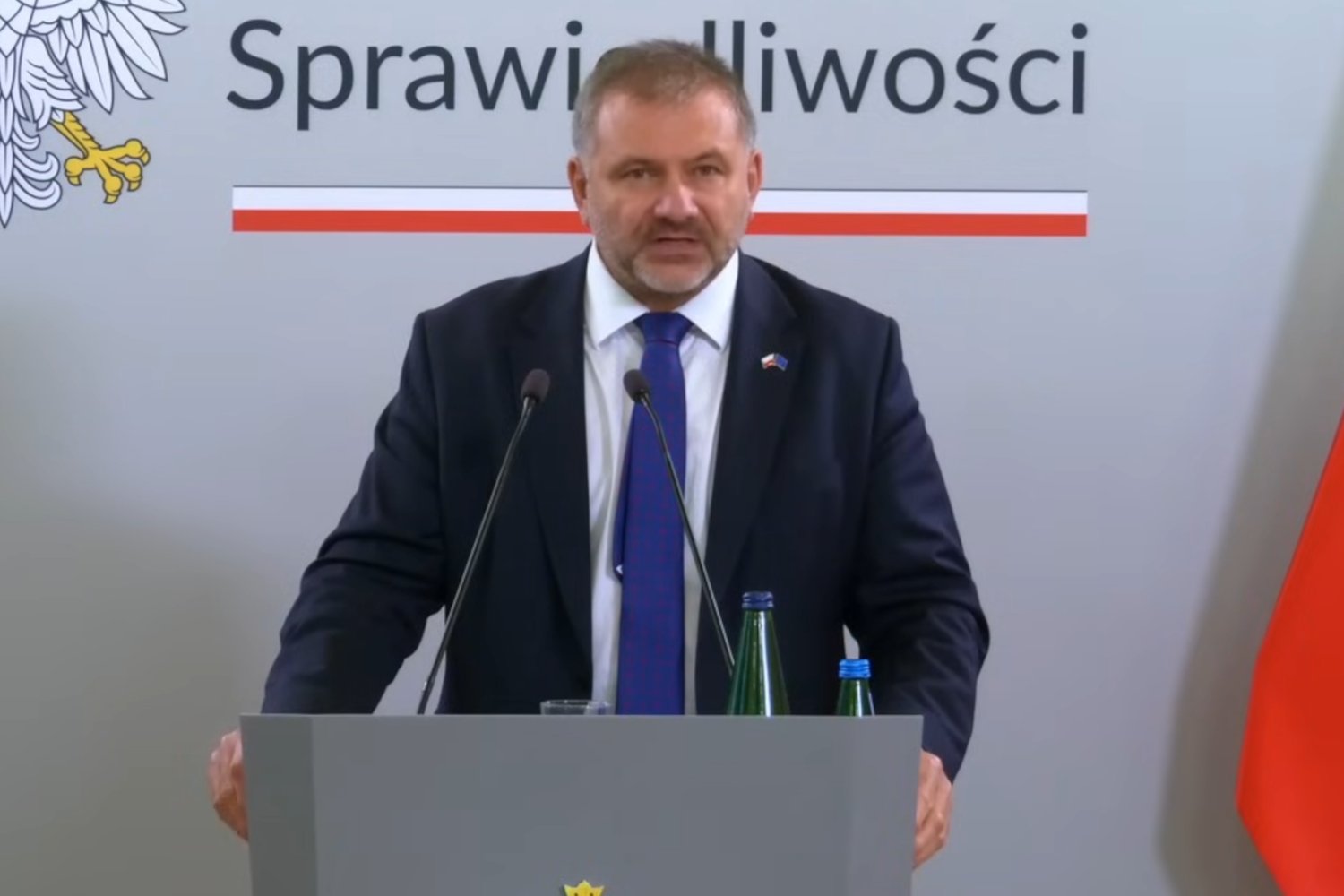 Mężczyzna w garniturze na mównicy