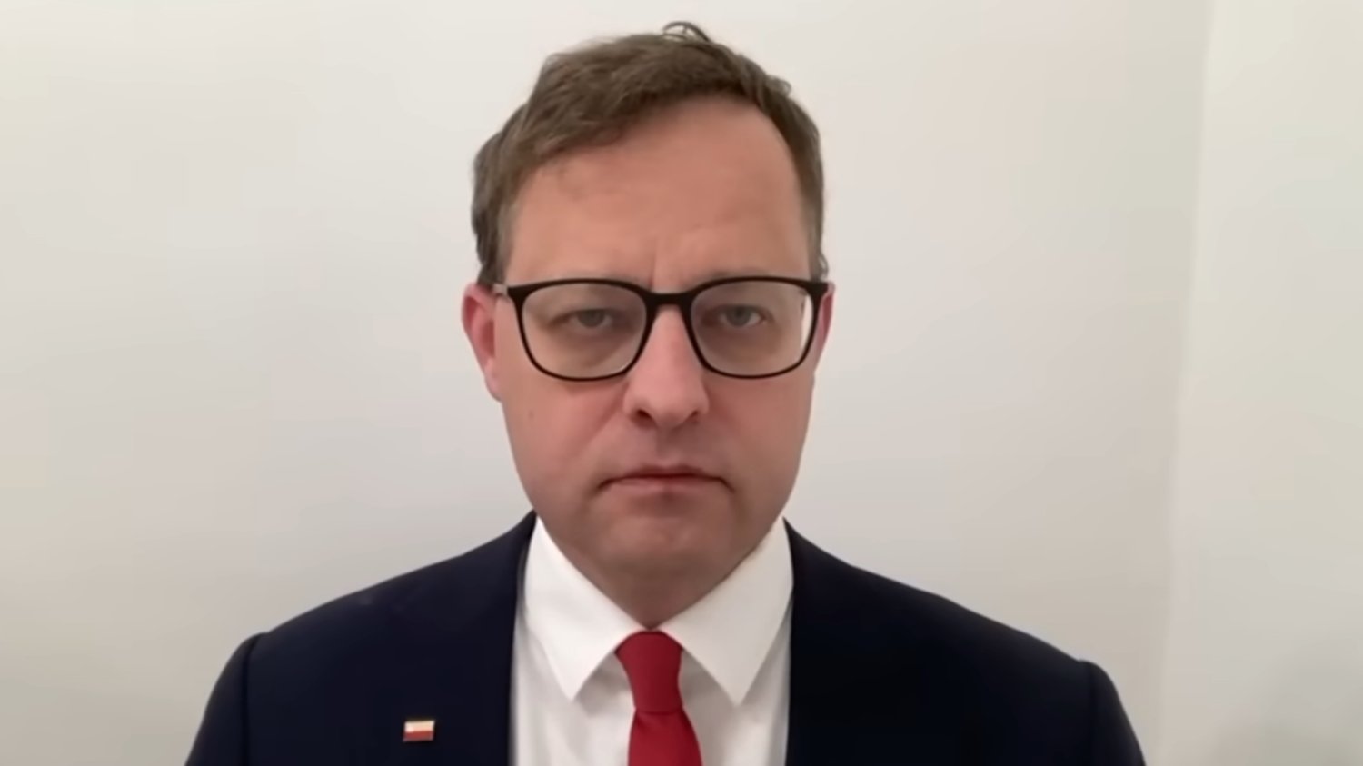 Marcin Romanowski poszukiwany ENA w Serbii Mężczyzna w garniturze na tle białej ściany