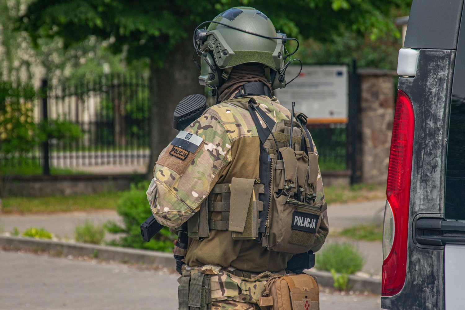 Przeszukania policji w Gromda Fight Club 9 września 2026 Policjant w mundurze z bronią zabezpiecza teren
