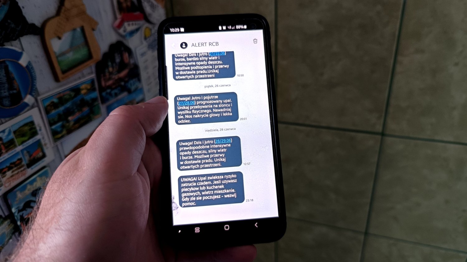 Nocny alert RCB o piecykach gazowych. Czad groźny też latem Ręka trzymająca smartfona z alertami RCB