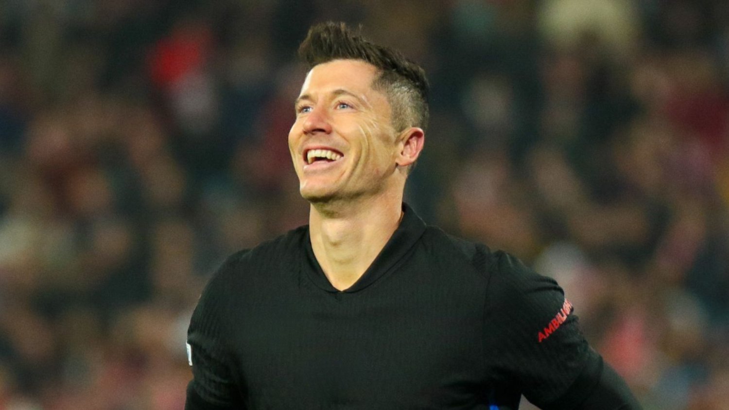 8 mln kibiców czeka na Roberta Lewandowskiego. Przeprowadzka roku dosłownie wisi w powietrzu Robert Lewandowski uśmiechnięty, w czarnej koszulce.