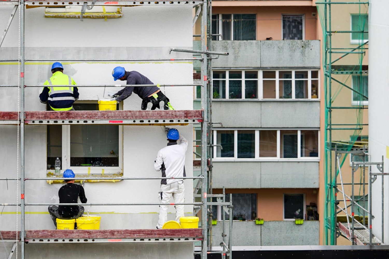 Robotnicy na rusztowaniu bloku. Deweloperzy twierdzą, że procedury hamują budowę nowych mieszkań