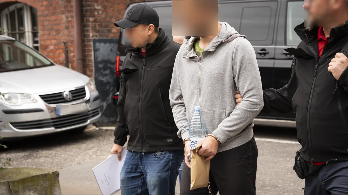 Policjanci prowadzą Michała S. po zatrzymaniu ws. zabójstwa 13-letniej Izy Michał S., podejrzewany o zabicie 13-letniej Izy, prowadzony przez policjantów